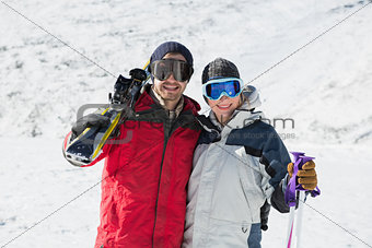 Portrait of a happy couple with ski boards on snow