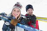 Close up of a smiling couple with ski boards on snow