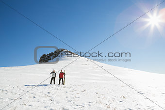 Couple with ski boards on snow on a sunny day