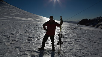 Silhouette man with ski board standing on snow