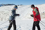 Smiling couple with ski poles on snow