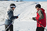 Side view of a smiling couple with ski poles on snow