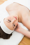 Brunette lying on massage table in beauty salon