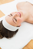 Smiling brunette lying on massage table in beauty salon