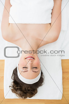 Young brunette lying on massage table with eyes closed