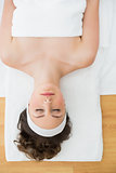 Young brunette lying on massage table with eyes closed