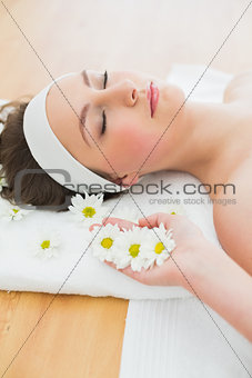 Beautiful woman with eyes closed lying in beauty salon