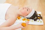 Beautiful woman with eyes closed and flowers in beauty salon