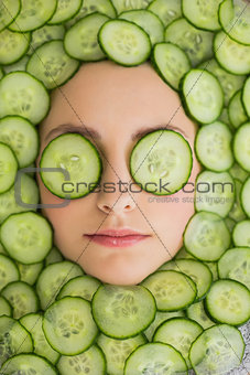 Beautiful woman with facial mask of cucumber slices on face