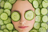 Beautiful woman with facial mask of cucumber slices on face