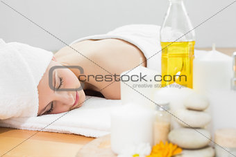 Beautiful woman and oil bottle at beauty spa