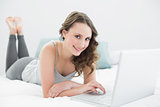 Casual brunette using laptop in bed