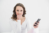 Shocked young woman with mobile phone