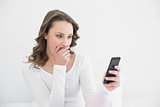 Shocked woman looking at mobile phone