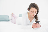 Woman looking at mobile phone in bed