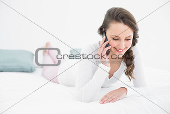 Beautiful woman using mobile phone in bed