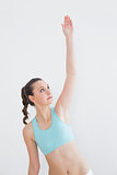 Sporty female stretching hand in fitness studio