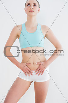 Serious toned woman standing against wall