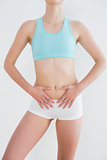 Mid section of a fit woman with hands on belly