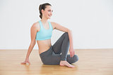 Fit woman in cowface posture in fitness studio