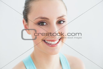 Smiling sporty woman against wall