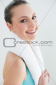 Fit woman with towel around neck against wall