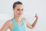 Fit woman with towel around neck against wall