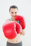 Portrait of a smiling woman in red boxing gloves