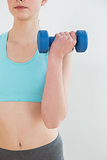 Close up mid section of woman with dumbbell