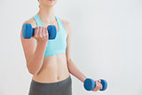 Close up mid section of woman with dumbbells