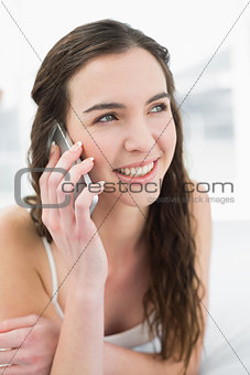 Relaxed woman using mobile phone in bed
