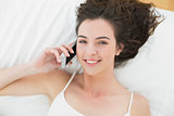 Portrait of relaxed woman using mobile phone in bed
