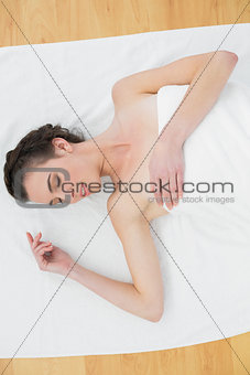 Beautiful woman lying on towel in beauty salon