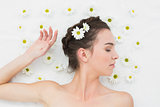 Beautiful young woman with flowers in beauty salon