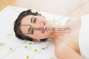 Beautiful young woman with flowers in beauty salon