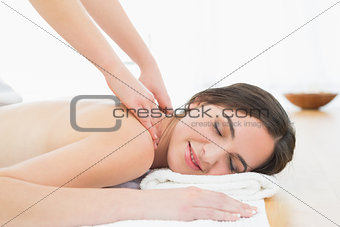 Beautiful woman enjoying neck massage at beauty spa