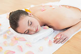 Beautiful woman resting on towel at beauty spa