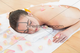 Beautiful woman resting on towel at beauty spa