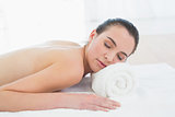 Topless beautiful woman resting on towel at beauty spa
