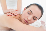 Beautiful woman enjoying back massage at beauty spa