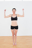 Sporty fit woman clenching fists in fitness studio