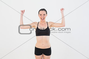 Sporty fit woman clenching fists against wall