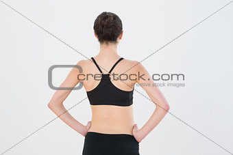 Rear view of toned woman standing against wall