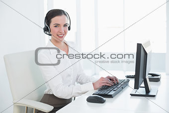 Businesswoman wearing headset while using computer