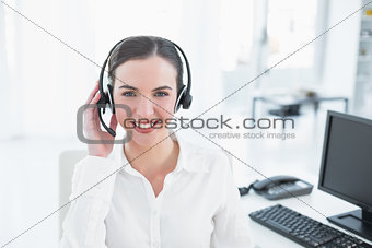 Smiling businesswoman wearing headset in office