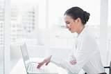 Smiling businesswoman using laptop at desk