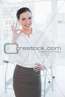 Elegant businesswoman gesturing ok sign in office