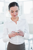 Businesswoman looking at mobile phone in office