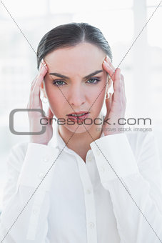 Elegant businesswoman suffering from headache
