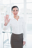 Elegant businesswoman waving hand in office